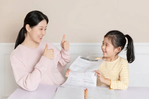 高得点の試験紙を誇るアジア系韓国人の娘 — ストック写真