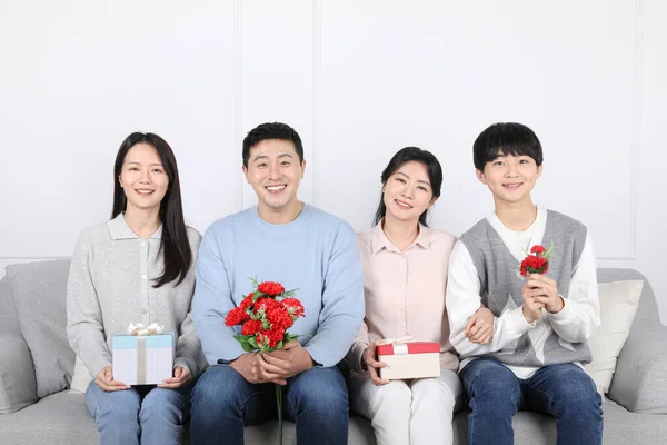 アジア系韓国人 カーネーションと贈り物を持つ家族の写真 — ストック写真