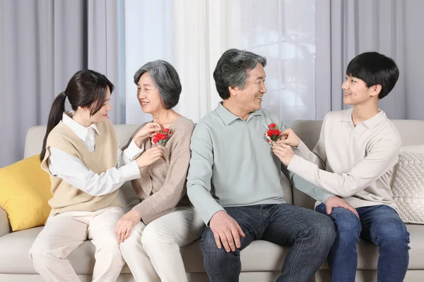 アジア系韓国人祖父母にカーネーションを与える孫 — ストック写真