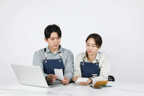アジア系韓国人の若者と女性スタートアップのコンセプト_領収書を見ながら心配している — ストック写真