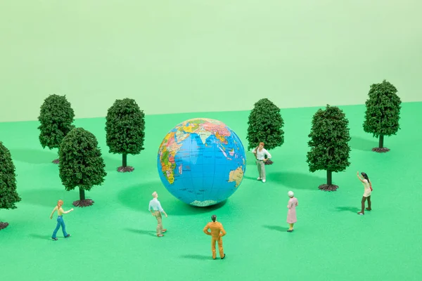 protect earth and environment concept, globe and people, forest miniature