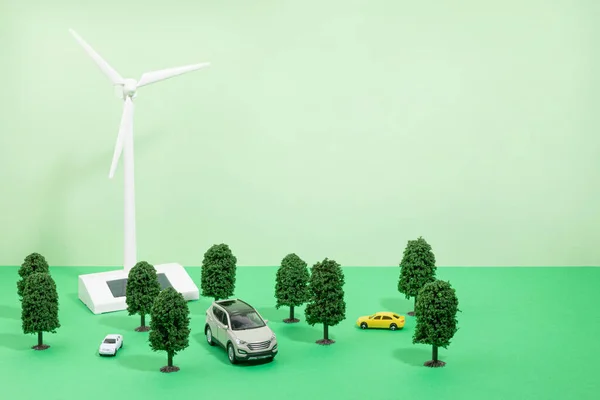 protect earth and environment concept, wind turbine, trees and cars miniatures