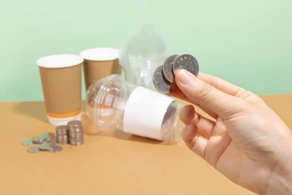 protect earth and environment concept, paper cup and plastic cups and coins, return for cash