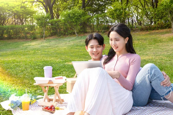 Asian Korean Couple Enjoying Spring Picnic_Watching Tablet — стокове фото