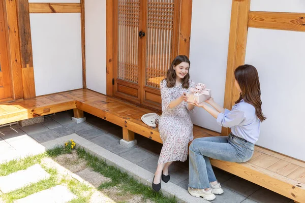 Experiencing Korean Traditions Hanok_Korean Girl Giving Souvenir Caucasian Girl — Stock Photo, Image
