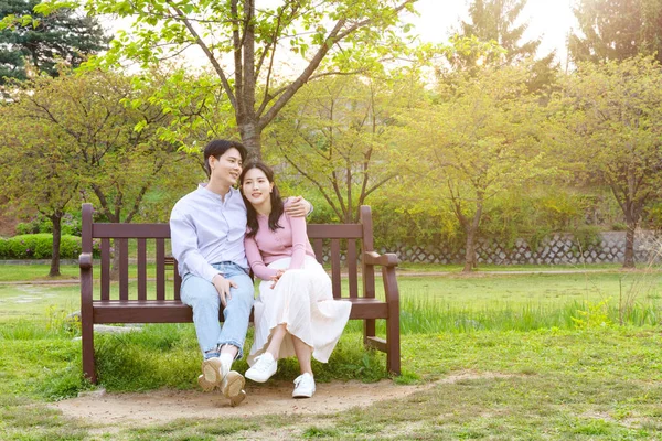 Korean Asian Couple Enjoying Spring Date_Sitting Bench — ストック写真
