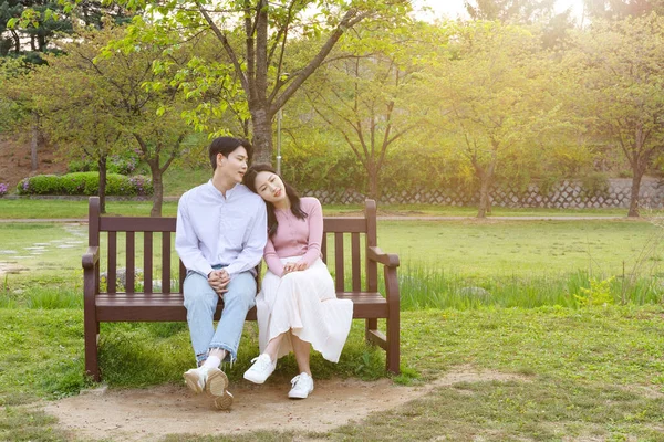 Korean Asian Couple Enjoying Spring Date_Sitting Bench —  Fotos de Stock