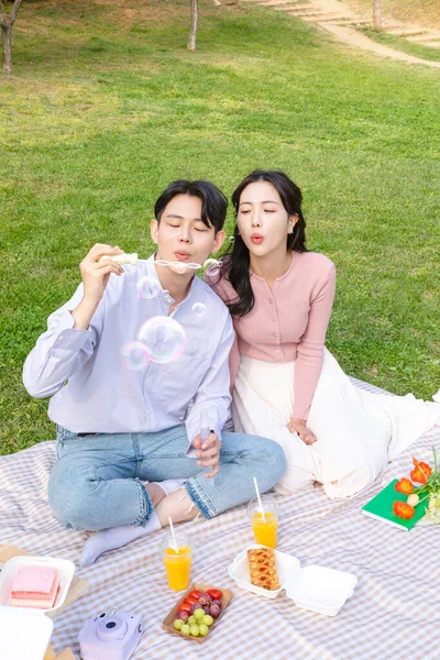 Asian Korean Couple Enjoying Spring Picnic_Playing Bubbles — Zdjęcie stockowe