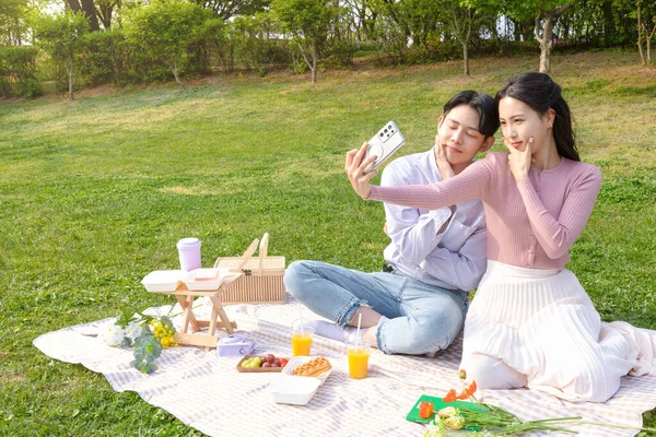 Asian Korean Couple Enjoying Spring Picnic_Taking Selfie — стокове фото