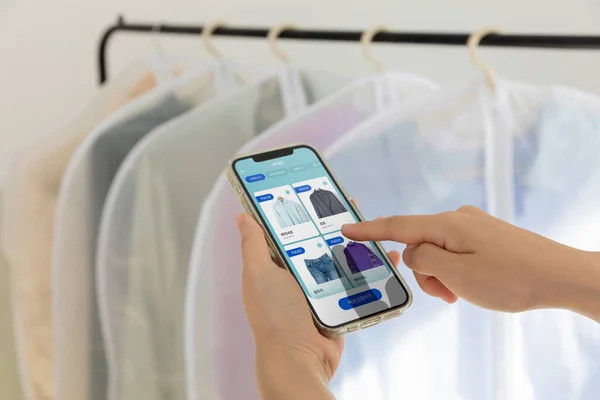 aesthetic laundry concept_laundry service app in smartphone, clothes rack background
