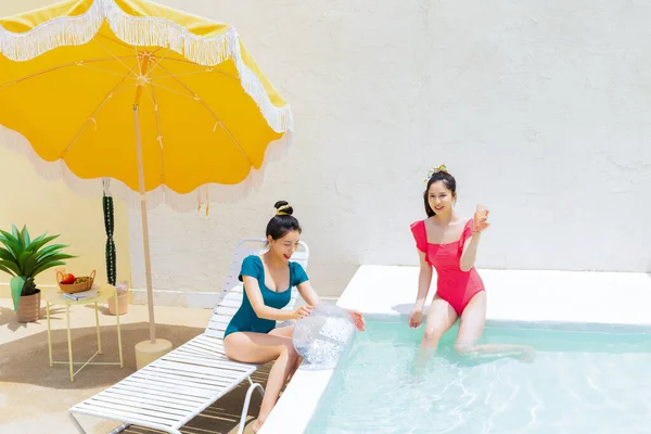 Yüzme Havuzunda Şişme Top Kokteyl Içen Iki Koreli Güzel Genç — Stok fotoğraf