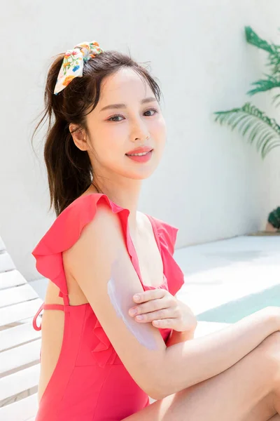 Κορεάτισσα Όμορφη Νεαρή Γυναίκα Που Εφαρμόζει Αντηλιακή Κρέμα Ενώ Κάθεται — Φωτογραφία Αρχείου