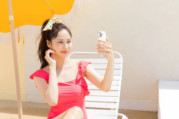 Mulher Coreana Vestindo Maiô Vermelho Relaxante Espreguiçadeira Usando Telefone Celular — Fotografia de Stock