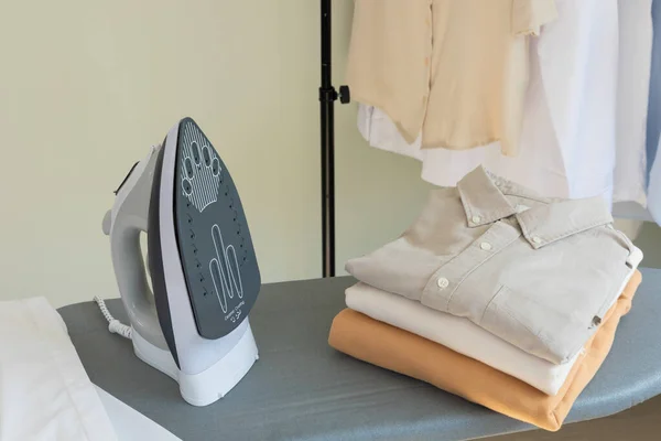 aesthetic laundry concept_folded clean clothes and iron