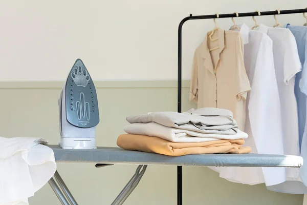 aesthetic laundry concept_folded clean clothes and iron