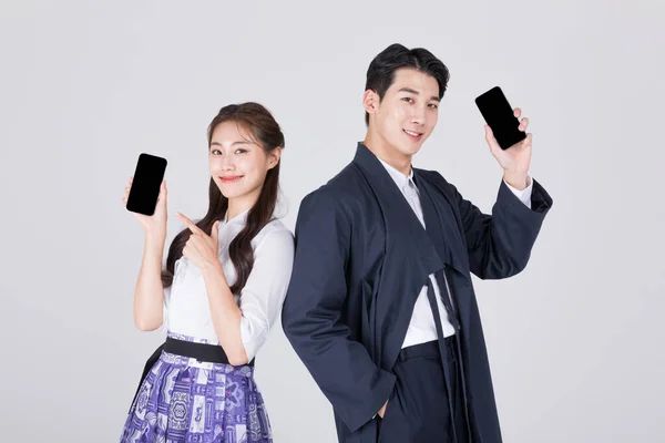 韩国一对20多岁的夫妇 身穿现代汉博克 手持智能手机 — 图库照片