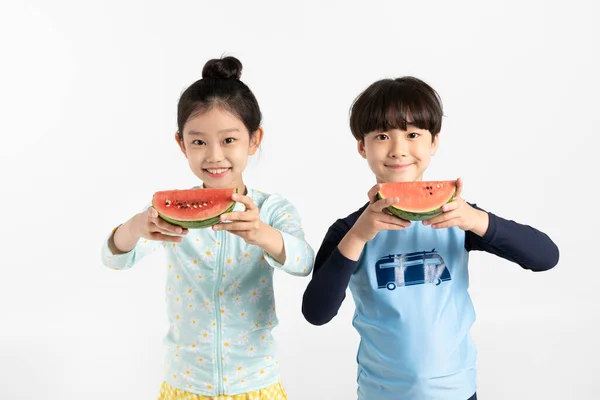 韩国男孩和女孩 夏天的概念在白色背景下持有西瓜 — 图库照片