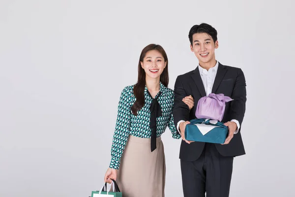 韩国年轻夫妇 男男女女 身穿现代汉博克 手持纸袋和礼品盒 — 图库照片