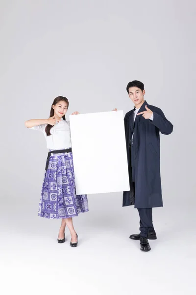 韓国のカップル 20代の若い男性と女性は 現代の韓服を着て コピースペースパネルを保持 — ストック写真