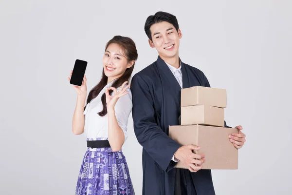 韩国一对20多岁的夫妇 身穿现代汉博克 手持智能手机和送货箱 — 图库照片
