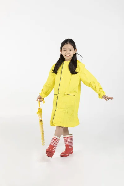 可爱的年轻韩国女孩 雨季的概念在白色背景工作室 穿着雨衣 拿着雨伞 — 图库照片