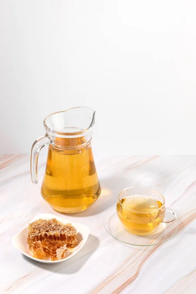 honey water in a glass bottle and teacup