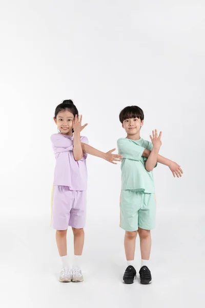 白种人背景下的韩国男孩和女孩的健身和锻炼理念 体操练习 — 图库照片