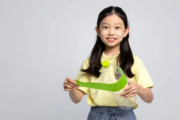 韩国女孩穿着白色背景音乐工作室的运动服 把塑料瓶标签分开 — 图库照片