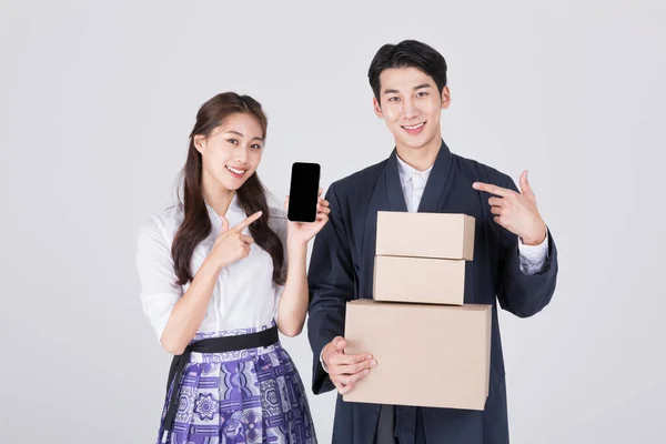 韩国一对20多岁的夫妇 身穿现代汉博克 手持智能手机和送货箱 — 图库照片
