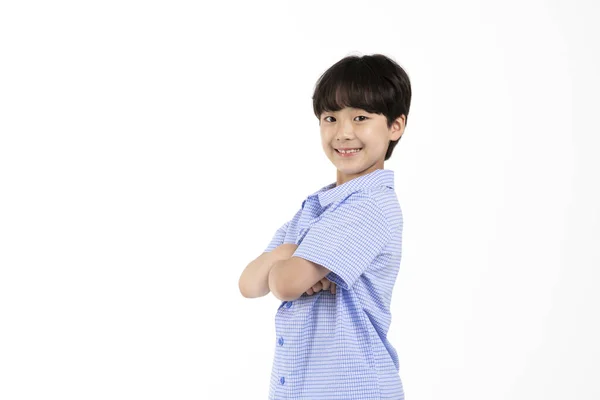白い背景のスタジオで夏の青い半袖シャツを着た韓国の少年_交差腕笑顔 — ストック写真
