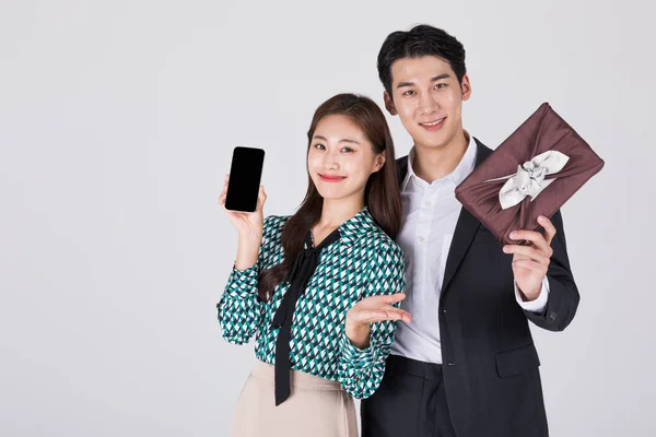 韩国年轻夫妇 男男女女 身穿现代汉博克 手持礼品盒和智能手机 — 图库照片