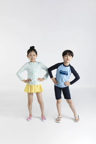 韩国男孩和女孩 夏天白色背景的概念 在水里玩耍前伸展 — 图库照片
