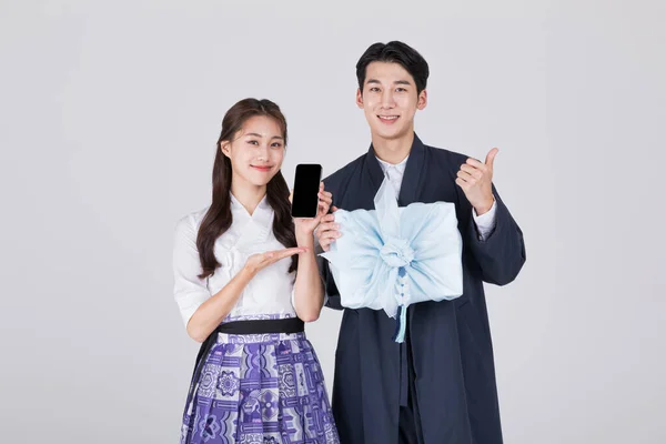 韩国一对20多岁的夫妇 身穿现代汉博克 手持传统的盒子和智能手机 — 图库照片