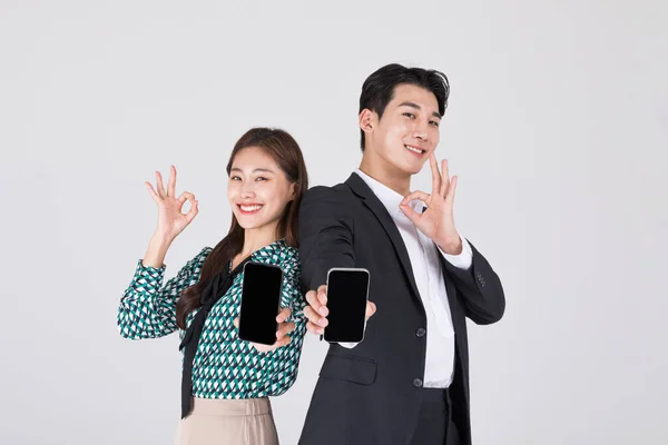 韩国年轻夫妇 男人和女人穿着现代汉博克 展示智能手机 — 图库照片