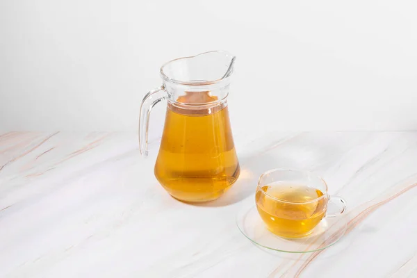 honey water in a glass bottle and teacup