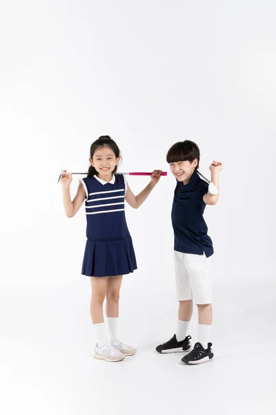 白人背景下的韩国男孩和女孩的健身和锻炼理念 摆动高尔夫球杆 — 图库照片