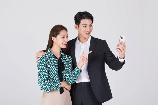 韩国年轻夫妇 男人和女人穿着现代汉博克 在看智能手机 — 图库照片