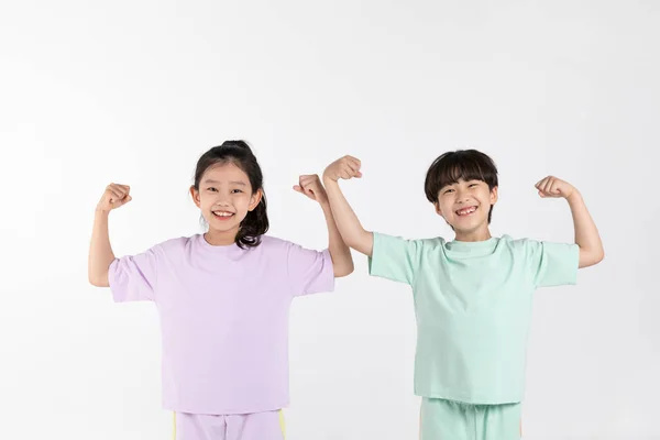 韩国男孩和女孩在白种人背景下的健身和锻炼观念 炫耀肌肉和力量 — 图库照片