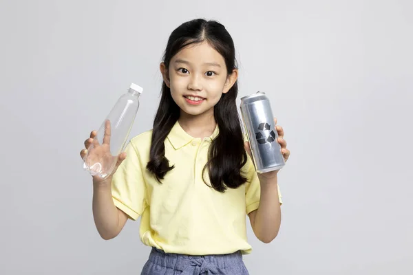 韩国女孩穿着白色背景工作室的运动服 拿着塑料瓶 — 图库照片