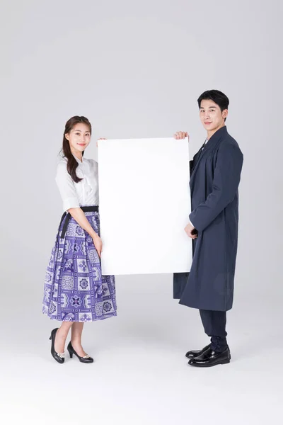 20多岁的一对韩国夫妇 身穿现代汉博克 手持复制空间面板 — 图库照片
