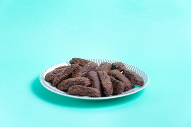 Turkuaz arka planda çikolata soslu kurabiye tabağı.