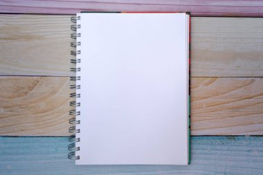 Top view of a plain white sheet notepad on a colorful madras background