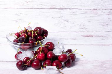 Çeşit çeşit kiraz ve buzlu cam kase.