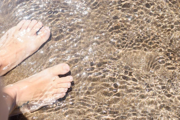 在海滨的水里 一双脚的选择性聚焦 — 图库照片