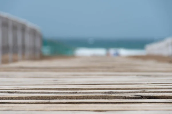 以大海为背景的沙滩上木制小路的选择性焦点 — 图库照片