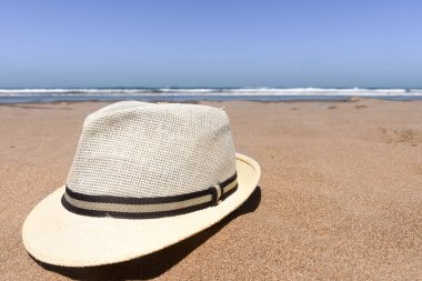 Boş kumsalda kumların üzerinde duran şapkanın seçici odağı