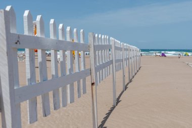 Sahilde arka planda deniz olan tahta çitin seçici odağı.