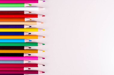 Düz arkaplan ve farklı renkte kalemler dizili