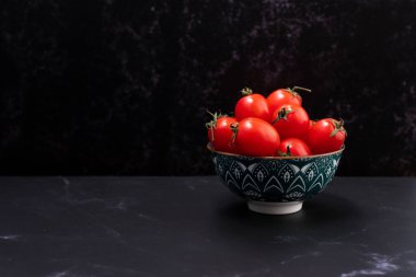 Side view of a set of cherry tomatoes in a container.