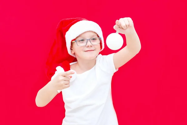산타클로스 모자를 크리스마스 손가락으로 가리키며 미소를 짓습니다 — 스톡 사진